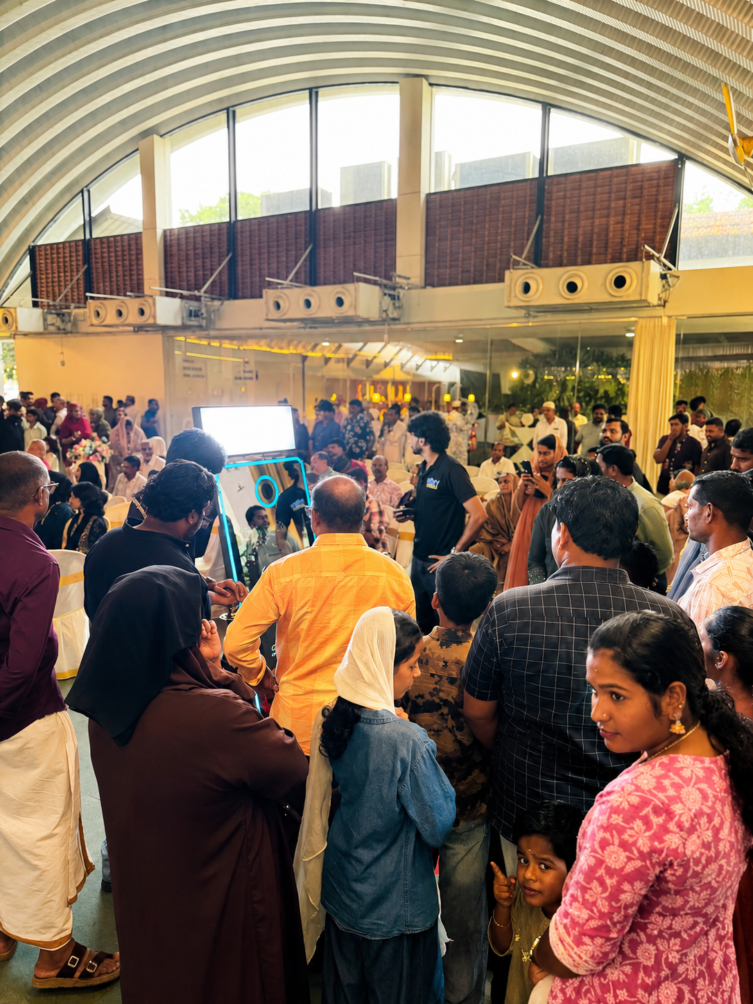 Guests gathered around a PartyBooth photobooth at a lively event
